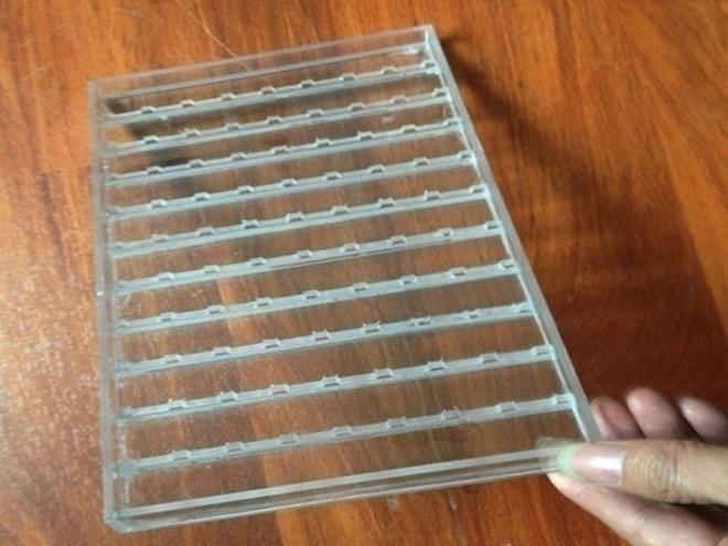 Transparent acrylic display tray with repeated product locating slots